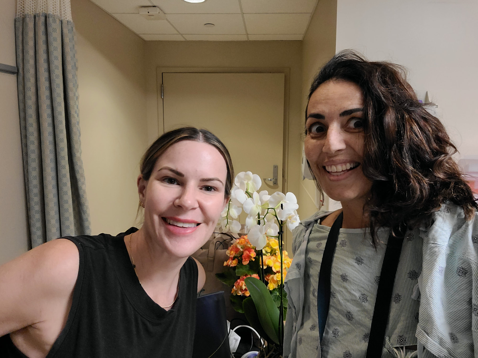 Toni with a friend and flowers in her hospital room